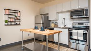 Portland apartment for rent - A modern kitchen with a wooden table and stainless steel appliances.