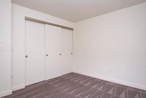 Portland apartment for rent - A room with a carpeted floor and a white wall with a white closet door.