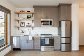 Portland apartment for rent - A modern kitchen with a stainless steel refrigerator, oven, and microwave.