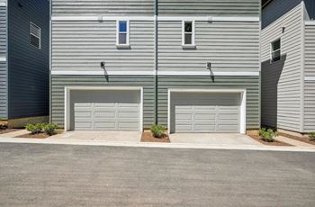 Two car garage doors with white trim and landscaping