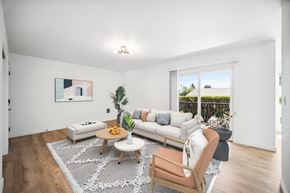 Vancouver apartment for rent - A living room with a white couch, a wooden chair, and a coffee table.