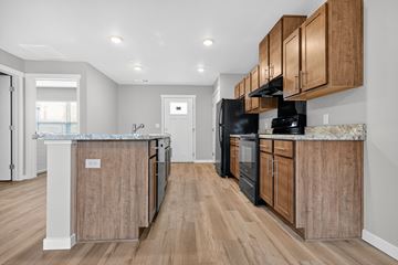 Oshkosh townhouse for rent - A kitchen with wooden cabinets and black appliances.