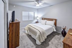 Hurley apartment for rent - A bedroom with a bed, dresser, and ceiling fan.