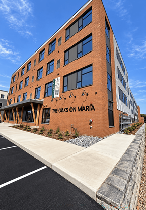 Stevens Point apartment for rent - The Oaks on Maria is a brick building with a parking lot in front.