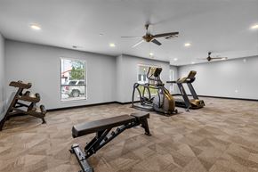 Oshkosh townhouse for rent - A spacious gym with a variety of equipment including treadmills, stationary bikes, and weight benches.