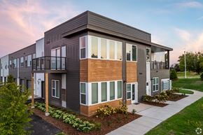 Saukville apartment for rent - A modern two-story apartment building with balconies and a well-maintained lawn in front at The Daniels at Northern Gateway Apartments, Saukville, WI