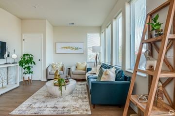 Saukville apartment for rent - A living room with a blue couch and a wooden ladder.