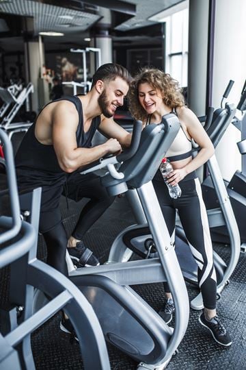 Stevens Point apartment for rent - A man and a woman are working out on exercise machines in a gym.