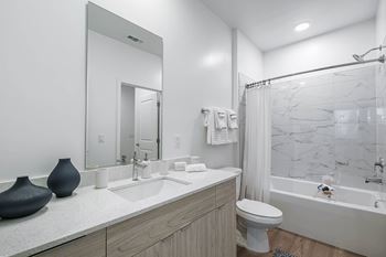 A bathroom with a marble shower and a white toilet