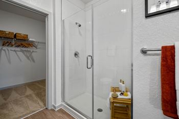 A bathroom with a glass shower door and a towel rack.