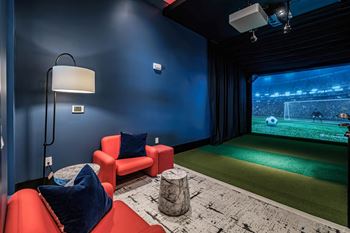A game room with a soccer field and a projector screen