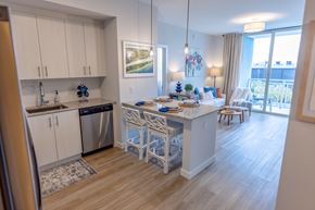 Hialeah apartment for rent - A kitchen with a dining table set for two with a view of the balcony.