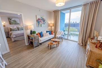 Hialeah apartment for rent - A living room with a white sofa and a wooden coffee table.