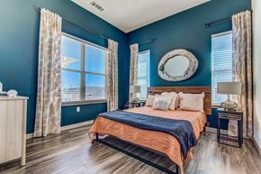 Lewisville apartment for rent - Apartments for Rent in Lewisville - Hebron 121 Station - Spacious Bedroom with Stylish Decor, Wood-Style Flooring, Large Windows, Two-Toned Walls, Bed, Nightstand, Lamps, and Dresser.