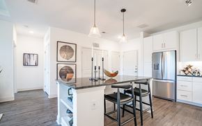 Atlanta apartment for rent - a kitchen with a large island with stools and a stainless steel refrigerator