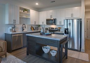 Antioch apartment for rent - Luxury Apartments In Antioch, TN With In-Unit Washer And Dryer - Mainstead At Century Farms - Modern Kitchen With White And Grey Cabinets, A Marble-Topped Island, And Stainless Steel Appliances.