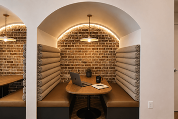 Kennesaw apartment for rent - A room with a brick wall and a table with a laptop and a mug on it.