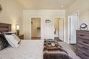Woodland Park apartment for rent - A bedroom with a large bed and a tray with plants and a bowl on it.
