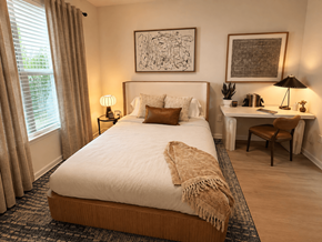 Atlanta apartment for rent - A bedroom with a large bed and a desk with a chair.