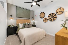 Huntsville apartment for rent - One-Bedroom Luxury Apartments in Huntsville, AL - The Arcadia - Bedroom with Plush Carpeting, Bed, Nightstands with Drawers, Dresser, Wall Decorations, and Ceiling Fan.