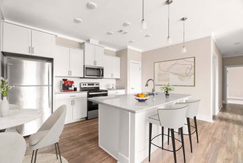 Stainless steel kitchen appliances including top freezer with icemaker, range, dishwasher, microwave, and disposal.