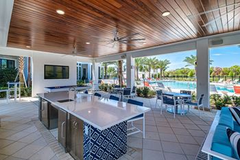 A kitchen with a wooden ceiling and a pool in the backyard