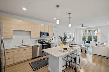 A modern kitchen with a large island and a dining area.