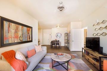 Colorado Springs apartment for rent - A living room with a grey couch and a painting on the wall.