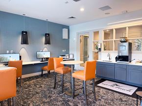 Jacksonville apartment for rent - A modern kitchen with orange chairs and a grey cabinet.