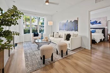 A living room with a white couch and a rug.