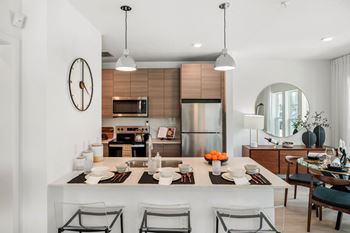 A modern kitchen with a large island and chairs.