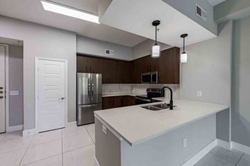 Sunrise apartment for rent - A kitchen with a white countertop and a stainless steel refrigerator.