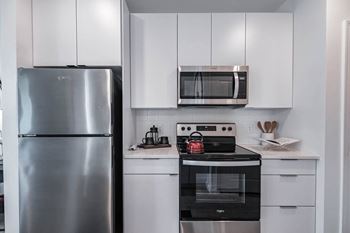 A modern kitchen with a stainless steel refrigerator and a black oven.