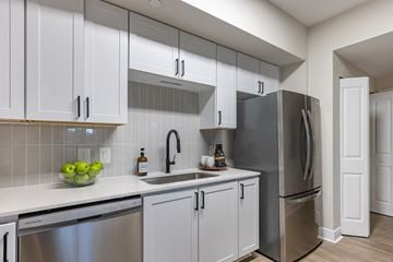 Coconut Creek apartment for rent - A kitchen with white cabinets and a stainless steel refrigerator.