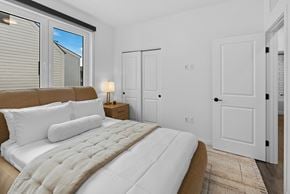 Bozeman townhouse for rent - 2 Bedroom Townhomes in Bozeman, MT - Highmark Bozeman - Bedroom With Luxury Wood-look Plank Flooring, Area Rug, Bed, Nightstand With Lamp, Closet, And Large Window.