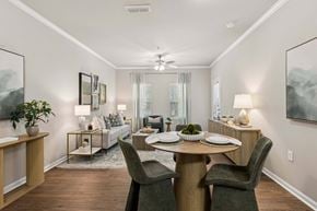 Pensacola apartment for rent - A dining room with a table set for two and a couch in the background.