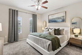 Pensacola apartment for rent - A bedroom with a large bed and a ceiling fan.