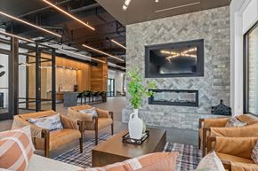 Huntsville apartment for rent - A living room with a stone fireplace and a flat screen TV mounted above it.