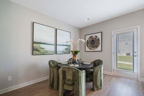 Mcdonough apartment for rent - A dining room with a table set for two and a view of the outdoors through the window.