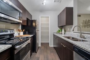 Decatur apartment for rent - A kitchen with dark wood cabinets and a black stove top oven.