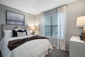 Decatur apartment for rent - A bedroom with a large bed and a window with white curtains.