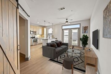 Duluth apartment for rent - A modern living room with a grey couch and a glass coffee table.