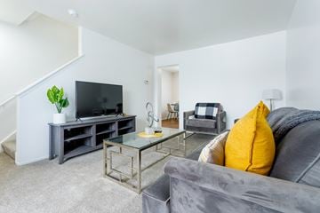 Ypsilanti apartment for rent - A living room with a grey couch and a glass coffee table.