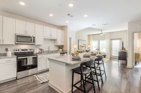 Charlotte apartment for rent - A modern kitchen with a bar area and a dining table set for four.