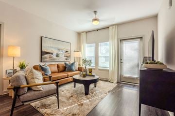 Charlotte apartment for rent - A living room with a grey couch, a coffee table, and a painting on the wall.