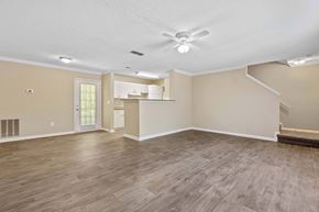 Loganville apartment for rent - A spacious room with a ceiling fan and lighting fixtures.