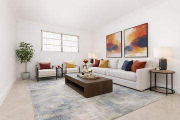 Hollywood apartment for rent - A living room with a white couch, a coffee table, and two paintings on the wall.