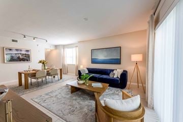 Miami apartment for rent - A living room with a blue couch and a painting on the wall.