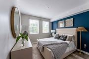Miami apartment for rent - A bedroom with a large bed and a round mirror on the wall.