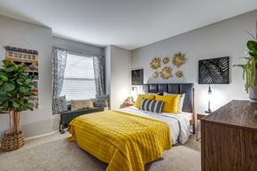Manassas apartment for rent - A bedroom with a yellow bedspread and a grey bed.